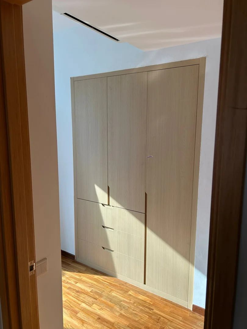Light wood built-in wardrobe with three accessible external drawers in a Singapore bedroom