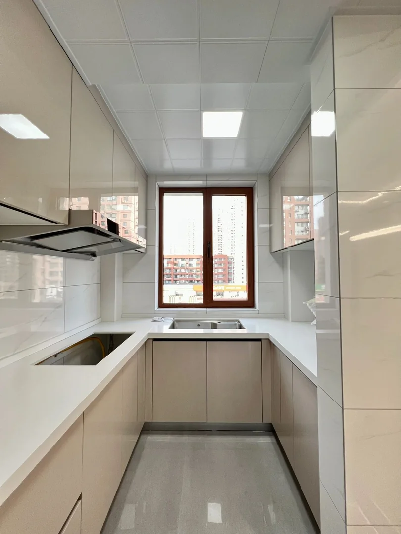 Compact white U-shaped kitchen cabinets with sink, hob and full-height storage in a Singapore home